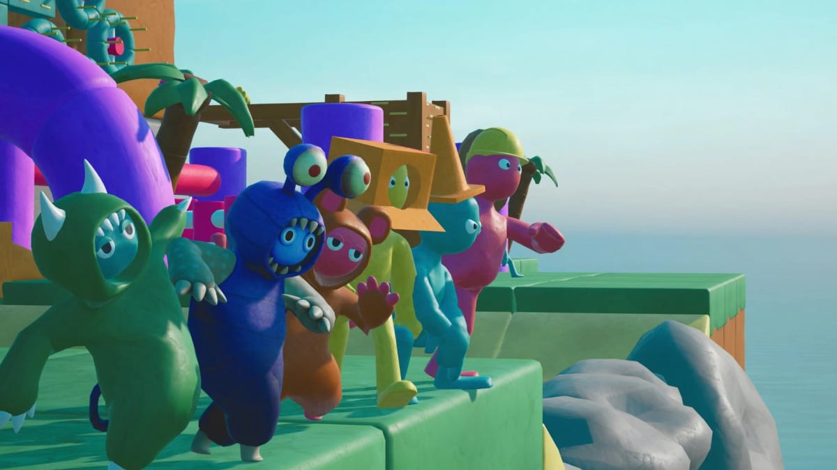 A crowd of clay creature characters packed onto a wooden platform floating above the sea
