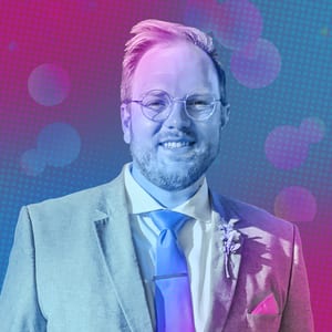 Headshot of JL, CMO of Clique Games, in a light suit and blue tie